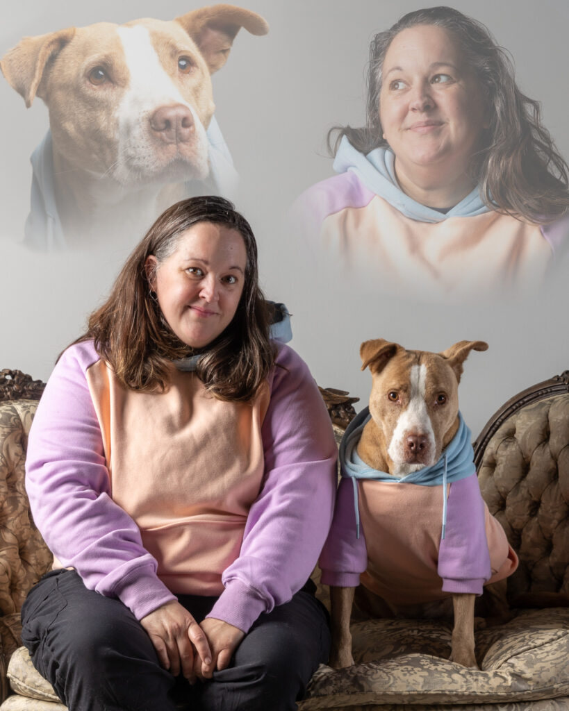 Self portrait of a white woman with shoulder-length brown hair sitting next to a pitbull type dog on a small couch. Both are wearing matching hoodies. The image has been altered so that there are partially transparent images of both the woman and the dog above.