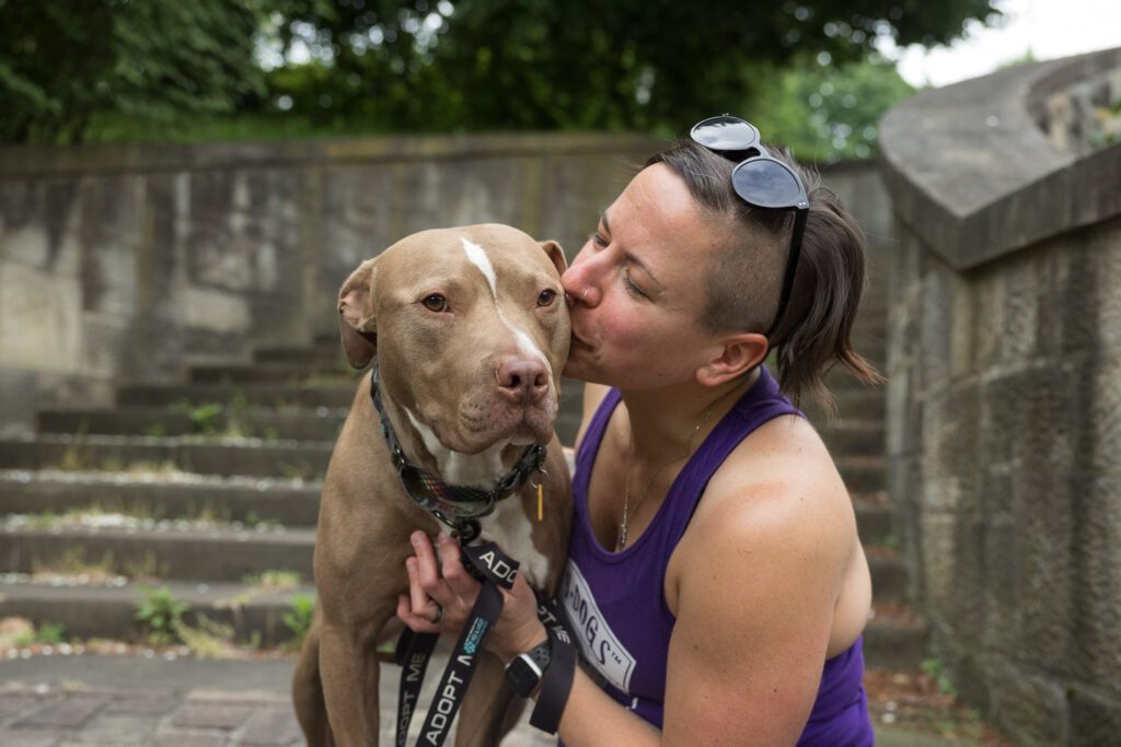 Outdoor photography Northeast Ohio: Tan pitbull being kissed by a person on the steps at the Cleveland Cultural Gardens