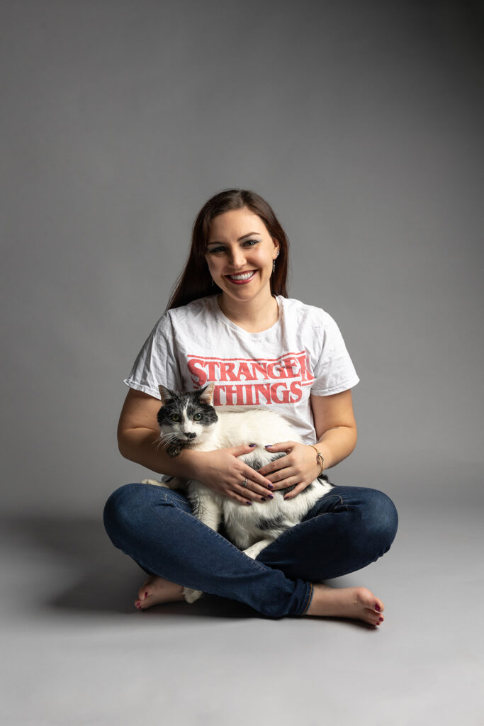 A woman and her cat sit on a grey backdrop in a Cleveland Ohio studio