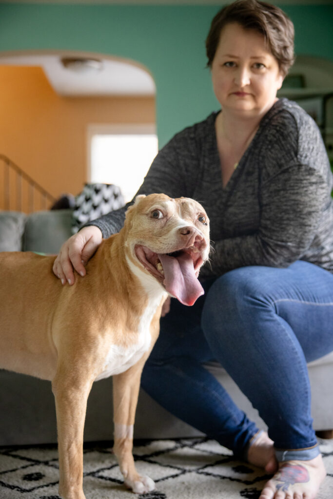 In-home photo session in Cleveland, Ohio with a pitbull and her mom both looking straight at the camera.