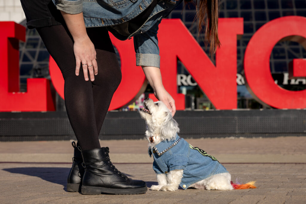 A small white dog and her human share a close moment outside of the Rock and Roll Hall of Fame in Cleveland Ohio